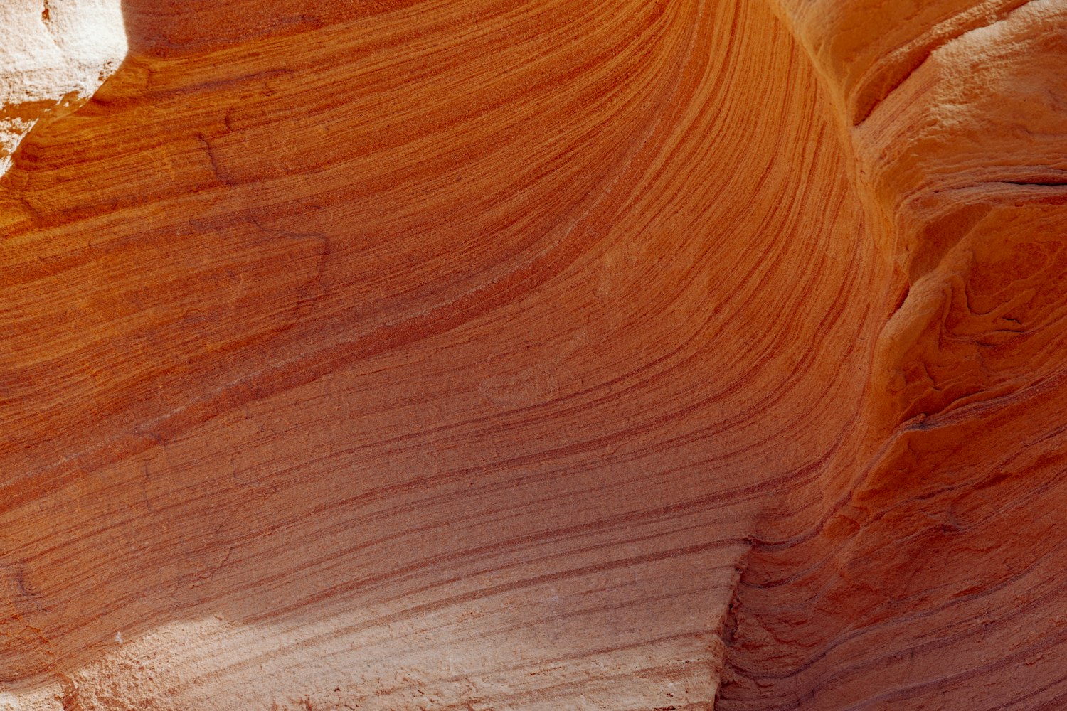 Smooth, evenly layered sandstone rock formation in warm tones