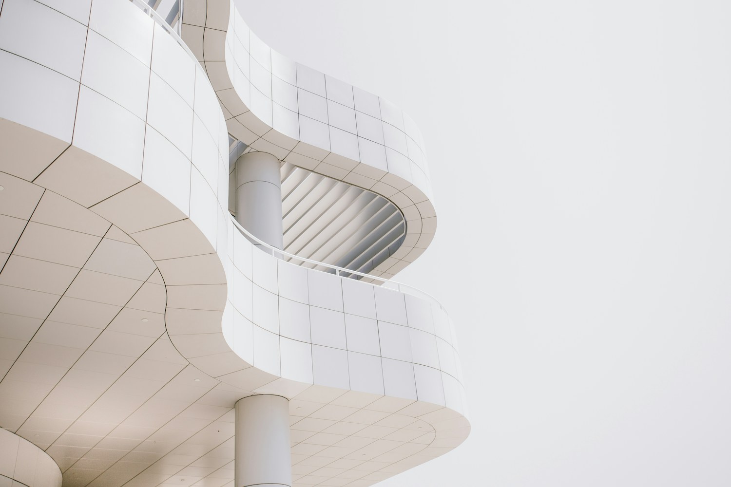 A worm's-eye view of a curved concrete building facade